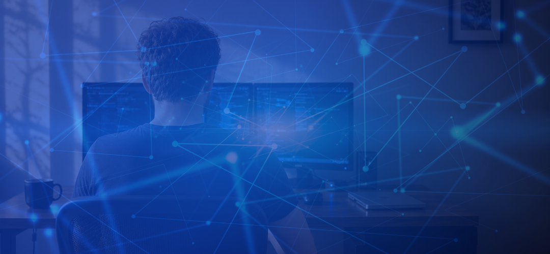 Silhouette of a person working at a dual-monitor computer setup at night, overlaid with a glowing blue network of connected nodes and lines.